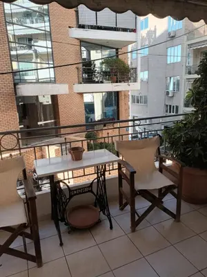 a table and chairs on the balcony of a building at Lovely apartment near Akropolis and Plaka in Athens