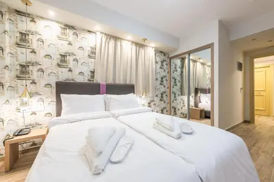 a bedroom with a large white bed with towels on it at Athens Lights in Athens