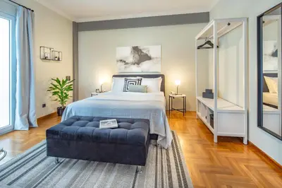 a large bedroom with a bed and a blue couch at Superb 1BD Apartment in the heart of Kolonaki by UPSTREET in Athens