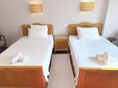 two twin beds in a room with towels on them at Friends & Family in Athens