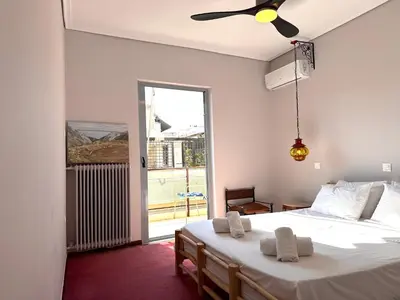 a bedroom with two beds and a large window at Friends & Family in Athens