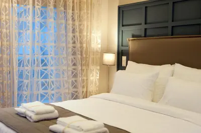 a bedroom with a bed with two towels on it at Athens Platinum Rooms and Suites in Athens