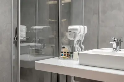 a bathroom with a phone on a counter next to a sink at Athens Platinum Rooms and Suites in Athens