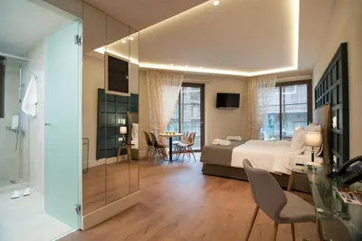a bedroom with a bed and a table with chairs at Athens Platinum Rooms and Suites in Athens