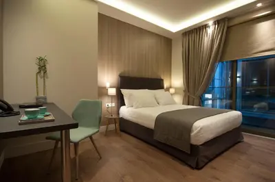 a bedroom with a bed and a desk and a window at Athens Platinum Rooms and Suites in Athens
