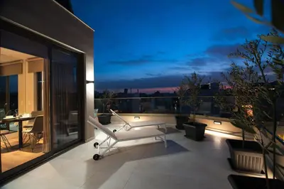 a white chair on a balcony with a view at Athens Platinum Rooms and Suites in Athens