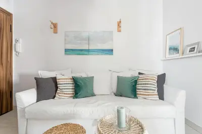a white living room with a white couch with pillows at Romantic Love-Nest Studio Near Acropolis & Metro in Athens