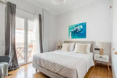 a white bedroom with a bed and a large window at Romantic Love-Nest Studio Near Acropolis & Metro in Athens