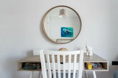 a white chair in front of a mirror at Romantic Love-Nest Studio Near Acropolis & Metro in Athens