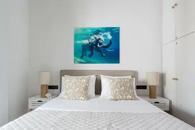 a bedroom with a white bed with a picture on the wall at Romantic Love-Nest Studio Near Acropolis & Metro in Athens