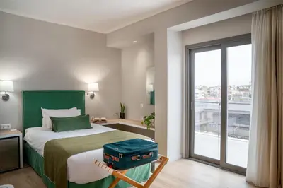 a bedroom with a bed with a suitcase on it at Chroma Fashion Rooms & Apartments in Athens