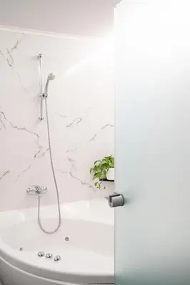 a bathroom with a bath tub with a shower at Chroma Fashion Rooms & Apartments in Athens