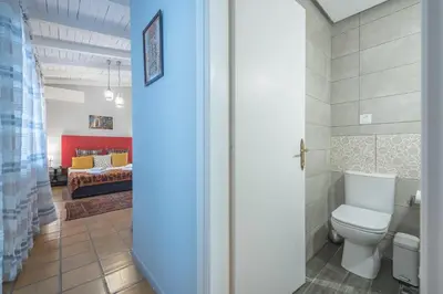 a bathroom with a toilet and a bedroom with a bed at Athenian Niche in Plaka Villa by Athenian Homes in Athens
