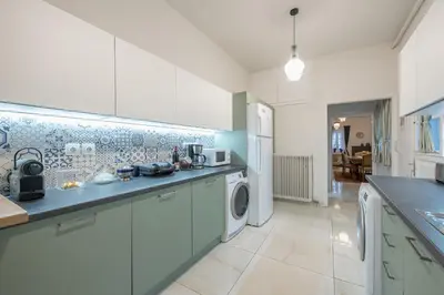 a kitchen with white cabinets and a washer and dryer at Athenian Niche in Plaka Villa by Athenian Homes in Athens