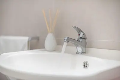 a bathroom sink with a faucet and a vase at Athenian Niche in Plaka Villa by Athenian Homes in Athens