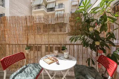 a white table and two chairs and a fence at Sweet home in Koukaki in Athens