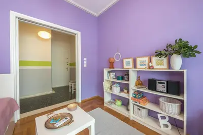 a living room with purple walls and a white shelf at Sweet home in Koukaki in Athens