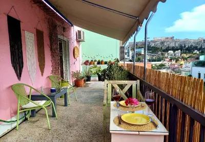 a balcony with a table and glasses of wine at Miaouli8 in Athens
