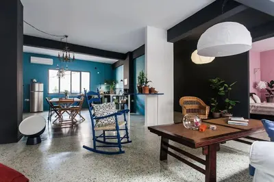 a living room with a table and chairs and a kitchen at Miaouli8 in Athens