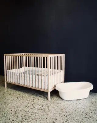 a crib and a bowl in a room with a wall at Miaouli8 in Athens