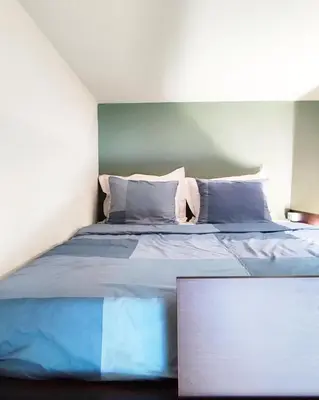 a bedroom with a bed with blue sheets and pillows at As Acropolis studio Apartment in Athens