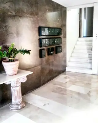 a room with a staircase and a table with a potted plant at As Acropolis studio Apartment in Athens