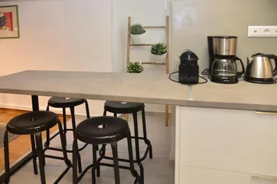 a kitchen with a counter with four bar stools at Athens Destination: a home away from home in Athens