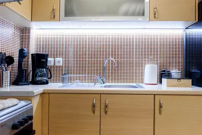 a kitchen with a sink and a tiled wall at M&D Luxury Suites in central Athens in Athens