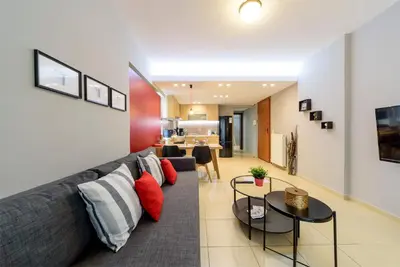 a living room with a gray couch and red pillows at M&D Luxury Suites in central Athens in Athens