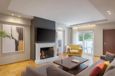 a living room with a fireplace and a tv at Athenian Grand Riviera Villa in Athens
