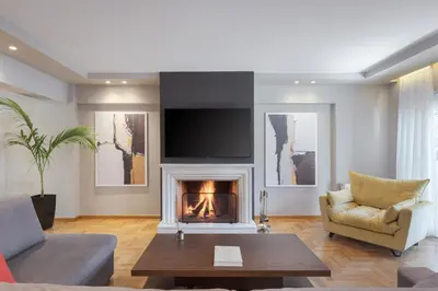 a living room with a fireplace and a tv at Athenian Grand Riviera Villa in Athens