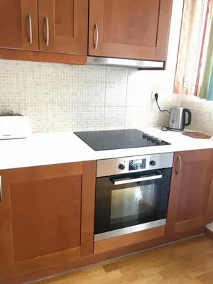 a kitchen with wooden cabinets and an oven at My Way Hotel in Athens