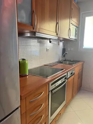 a kitchen with wooden cabinets and a stainless steel refrigerator at My Way Hotel in Athens