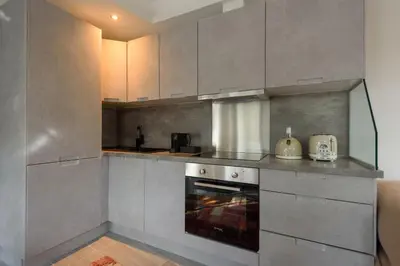 a kitchen with gray cabinets and an oven at Fos Residential Apartments in Athens