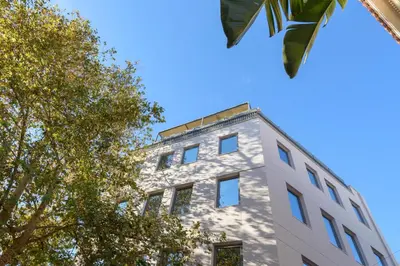 a tall white building with trees in front of it at Fos Residential Apartments in Athens