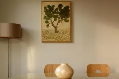 a painting of a tree on a wall with a table at Fos Residential Apartments in Athens