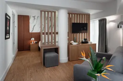 a living room with a couch and a tv at Elia Ermou Athens Hotel in Athens