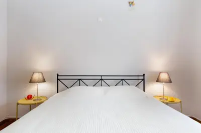 a bedroom with a large white bed with two lamps at M&N Koukaki House in Athens