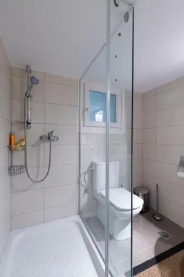 a bathroom with a toilet and a glass shower at M&N Koukaki House in Athens