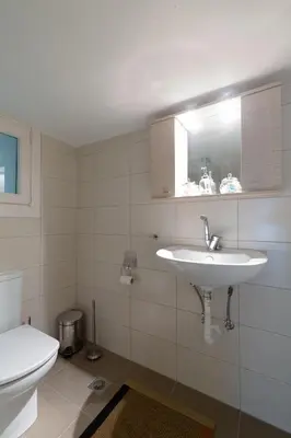 a white bathroom with a sink and a toilet at M&N Koukaki House in Athens