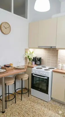 a kitchen with a stove and a table with stools at Luxury apartments near Acropolis! in the Heart of Athens! in Athens
