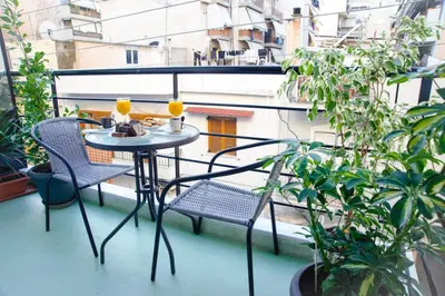 a small table and chairs on a balcony with plants at Luxury apartments near Acropolis! in the Heart of Athens! in Athens