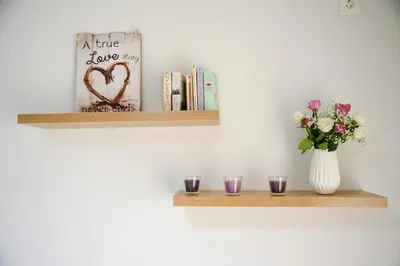 a shelf with a vase of flowers and books at Luxury apartments near Acropolis! in the Heart of Athens! in Athens