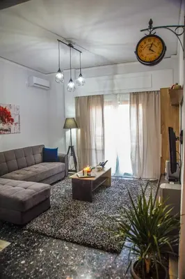 a living room with a couch and a clock on the wall at Luxury apartments near Acropolis! in the Heart of Athens! in Athens