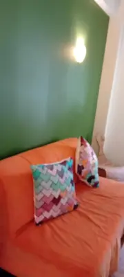 an orange bed with two colorful pillows on it at By Lycabettus in the city-heart close to Acropolis in Athens