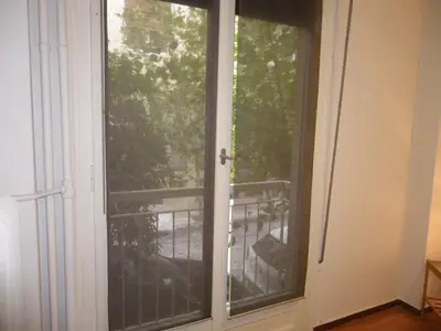 a sliding glass door with a view of a balcony at By Lycabettus in the city-heart close to Acropolis in Athens