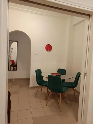 a dining room with a table and green chairs at By Lycabettus in the city-heart close to Acropolis in Athens
