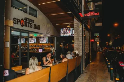 a group of people sitting at a bar at Athens Studios in Athens