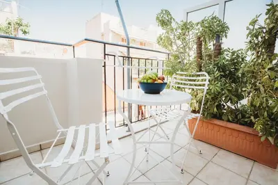 a table and chairs on a balcony with plants at Athens Studios in Athens