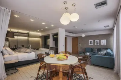 a living room with a bed and a table and chairs at Sweet Home Hotel in Athens